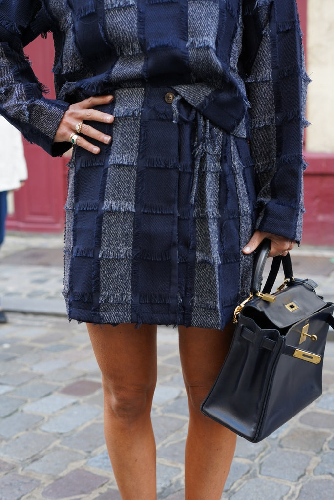 Une jolie jupe courte avec un tissu jacquard bleu et des franges